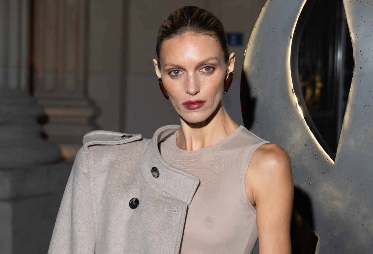  Anja Rubik w beżowym płaszczu i tiulowej naked dress pojawiła się na pokazie Saint Laurent. Styl Anji Rubik dopełniały czółenka typu slingback.