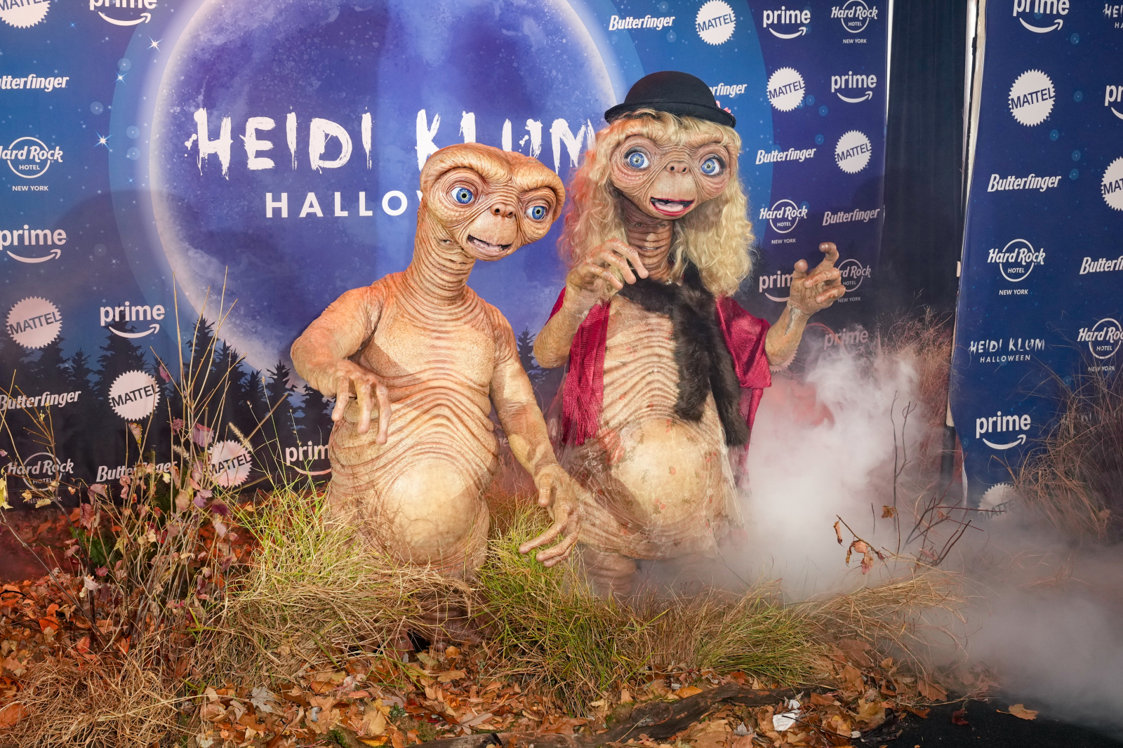 Heidi Klum i Tom Kaulitz przebrani za postacie z filmu "E.T.", otoczeni roślinnością na imprezie Halloween.