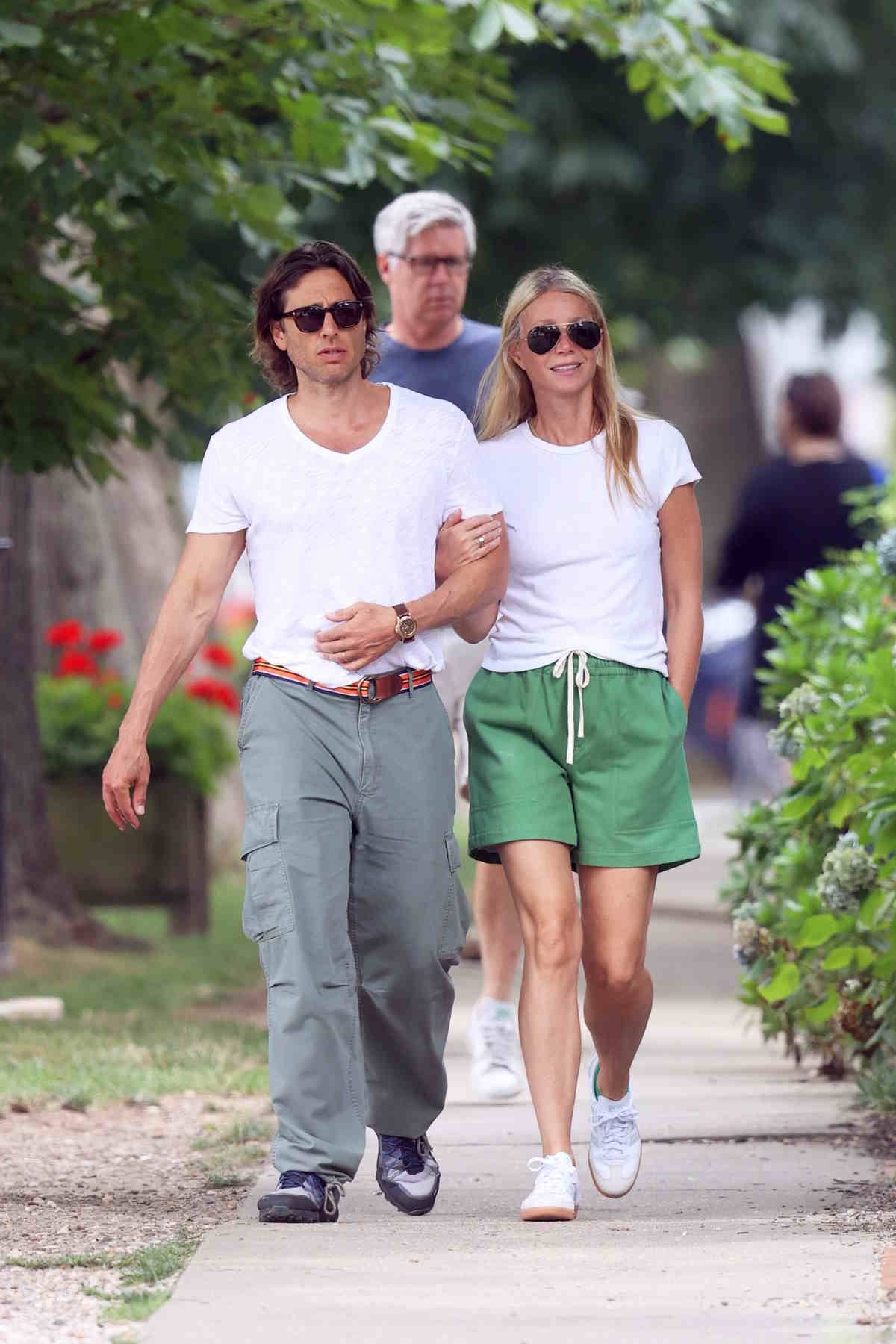 Gwyneth Paltrow z mężem w casualowych stylizacjach ze sneakersami.