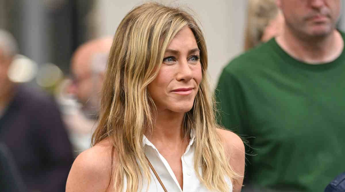 Jennifer Aniston w białej koszuli bez rękawów, idealnej na upalne dni.