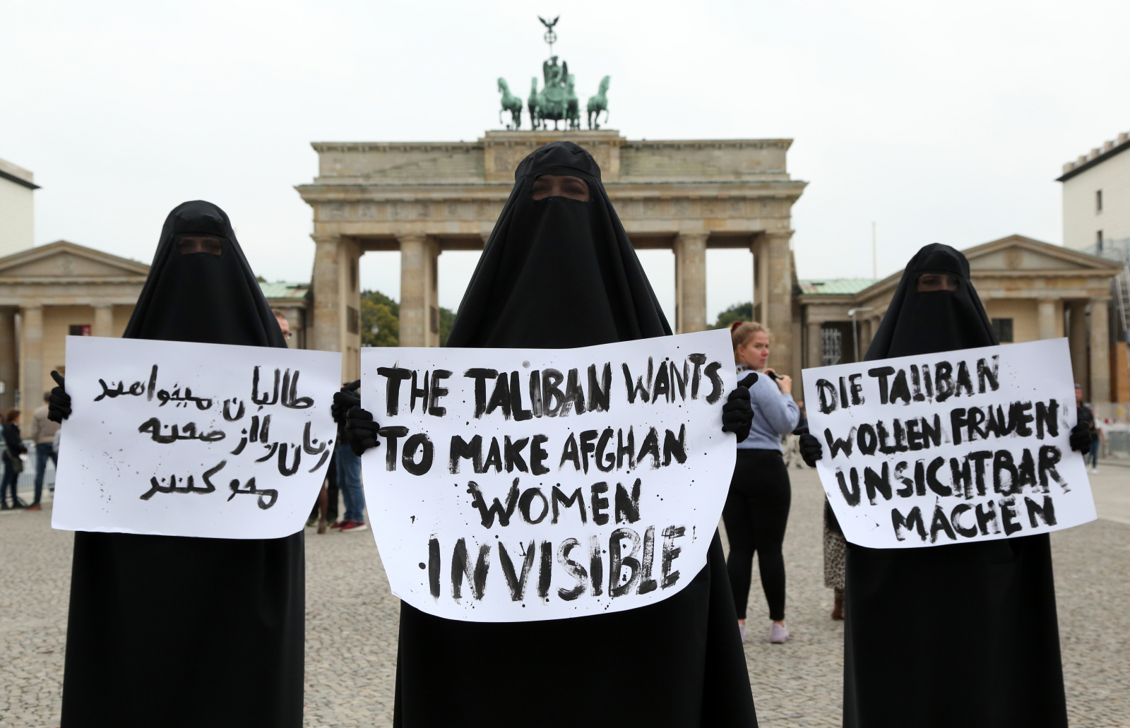 Członkinie feministycznej grupy aktywistek Femen noszą burki, protestując w solidarności z afgańskimi kobietami z transparentami z napisem „Talibowie chcą uczynić afgańskie kobiety niewidzialnymi” w języku perskim, angielskim i niemieckim, 25 września 2021 r. w Berlinie w Niemczech, wrzesień 2021 (Fot. Adam Berry/Getty Images)