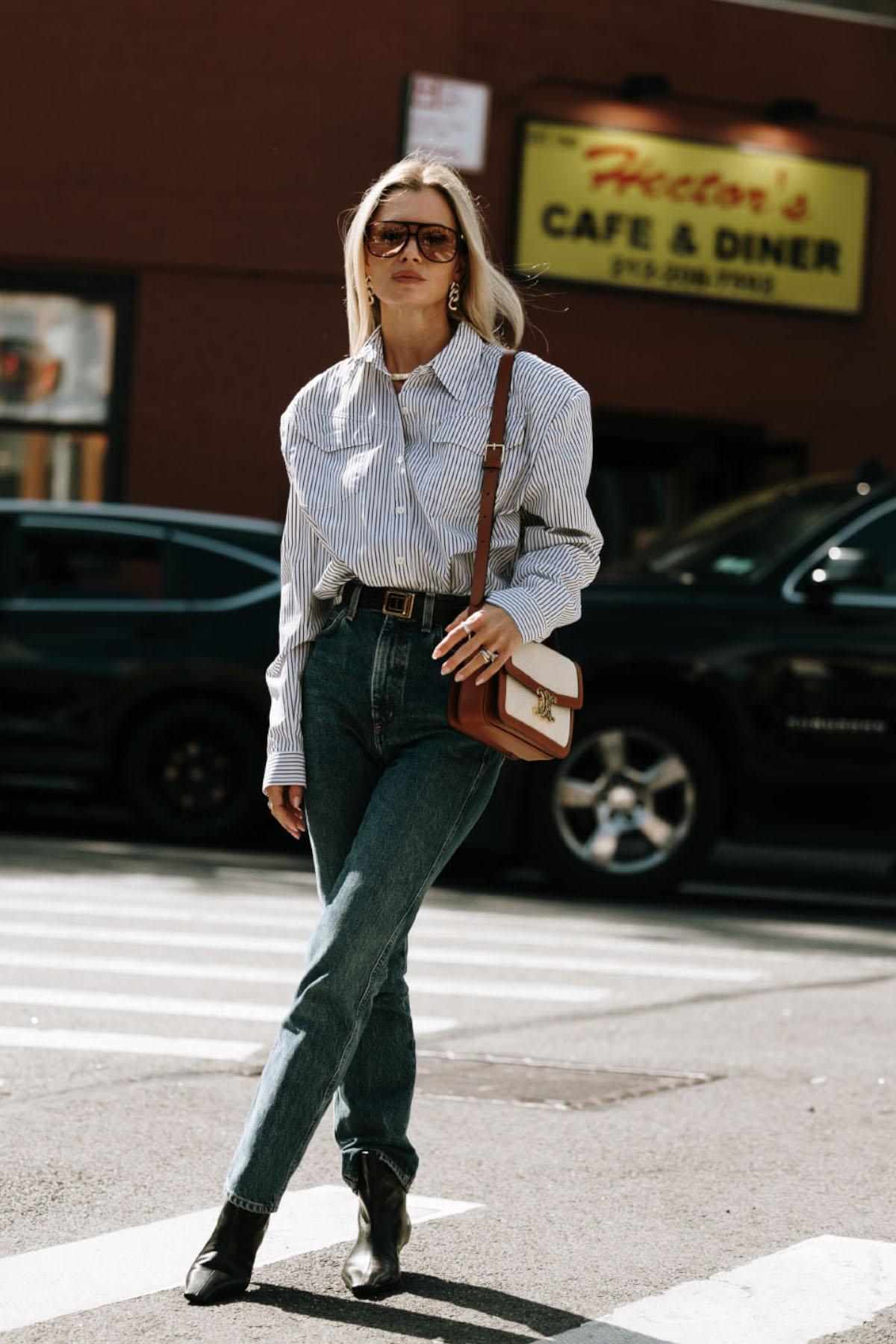 It-girl na nowojorskim tygodniu mody w luźnej koszuli, skinny jeans i botkach.