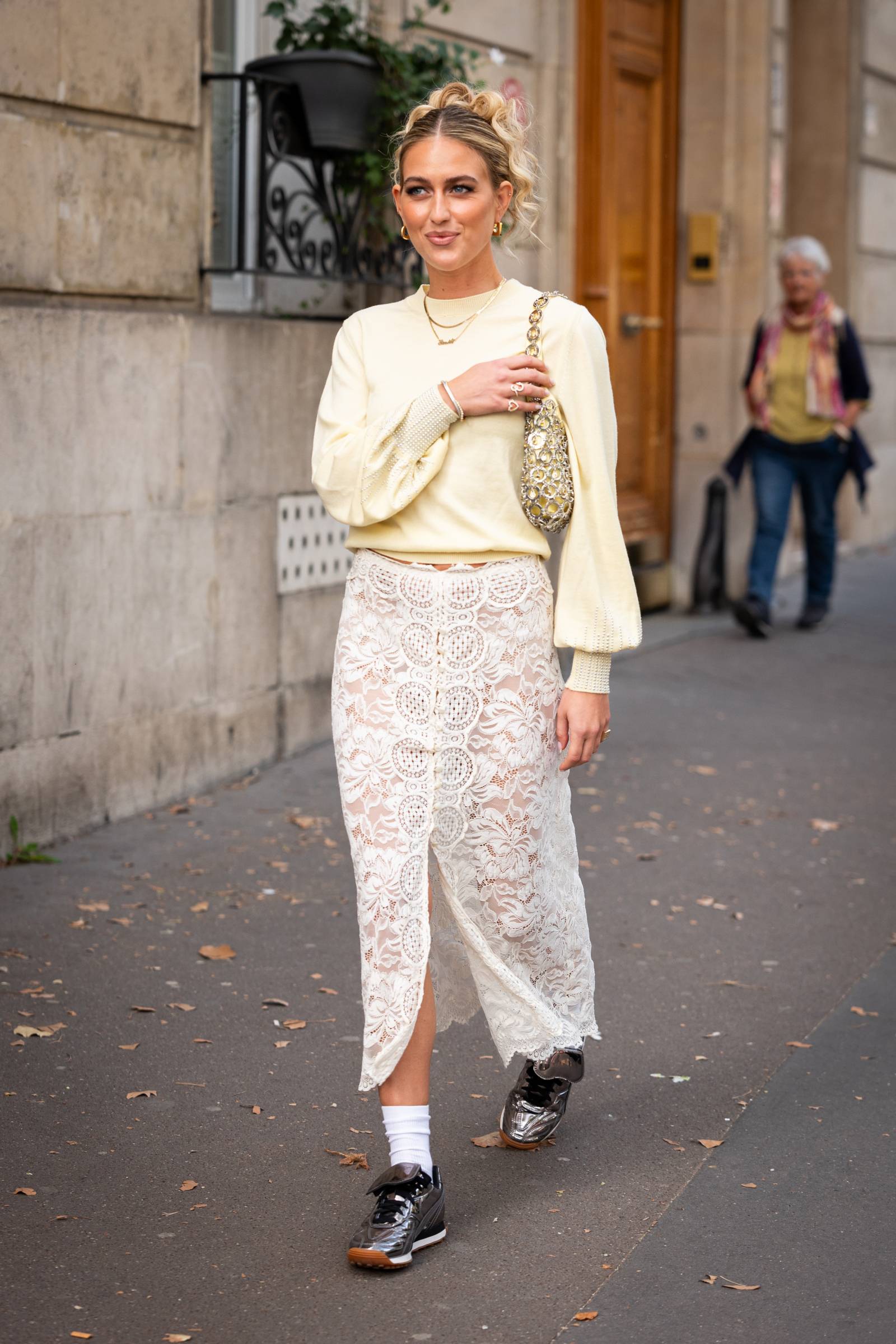 Romantycznie i casualowo: sportowa maślana bluza i kremowa spódnica z koronki / tydzień mody w Paryżu, wrzesień 2023 (Fot. Getty Images)