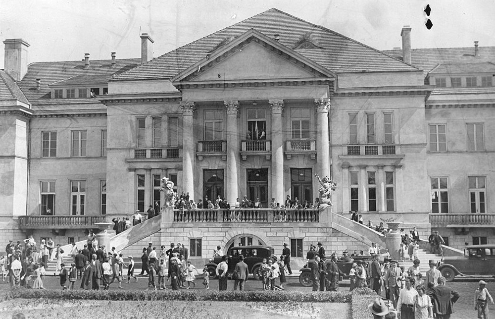 Kasyno w Otwocku z 1932 roku, z tłumem ludzi przed głównym wejściem i klasyczną architekturą.