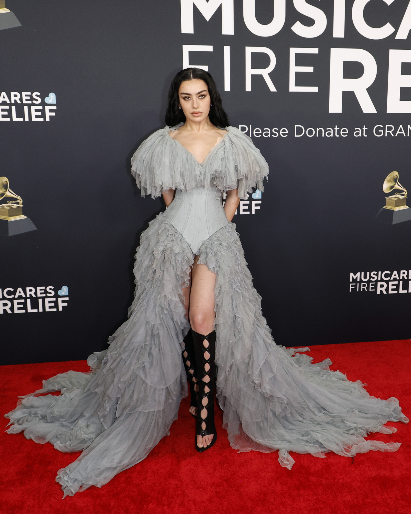 Charli XCX w gotyckiej sukience Jean Paul Gaultier z falbanami, prezentująca się na czerwonym dywanie Grammy 2025.