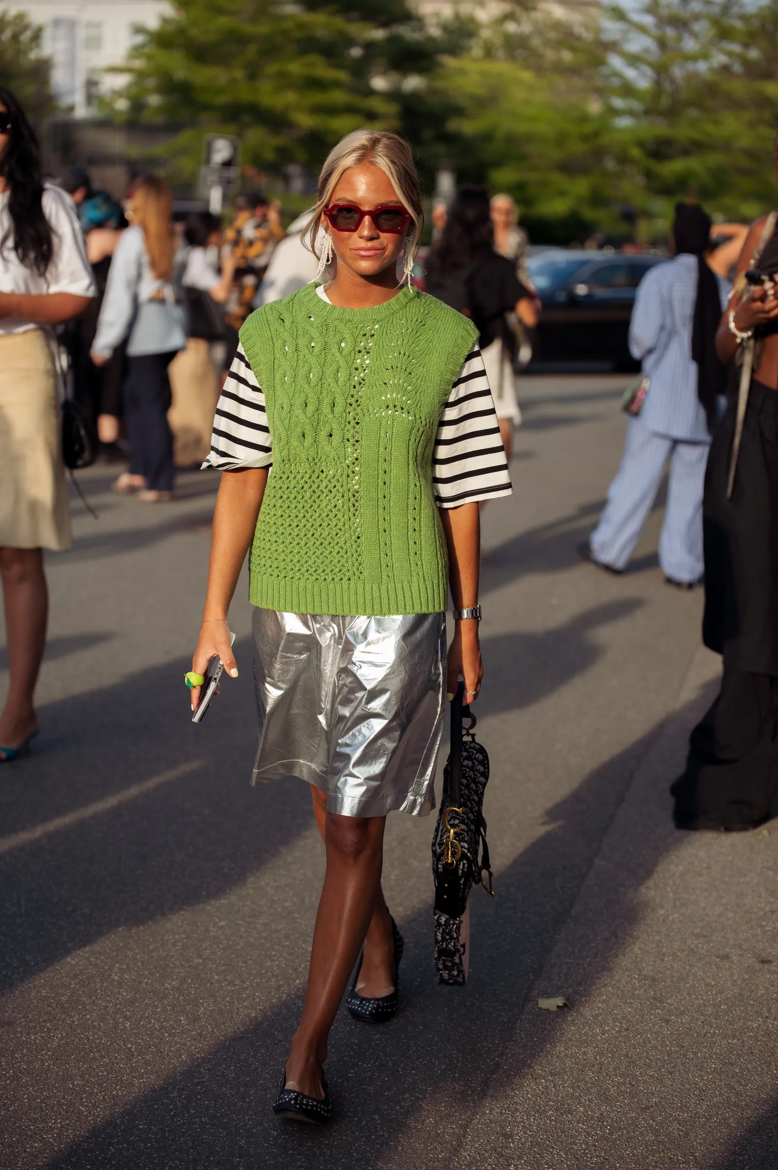 Street style: zielona dzianinowa kamizelka w połączeniu z koszulką w paski i srebrną spódnicą. (Fot. Raimonda Kulikauskiene/Getty Images)