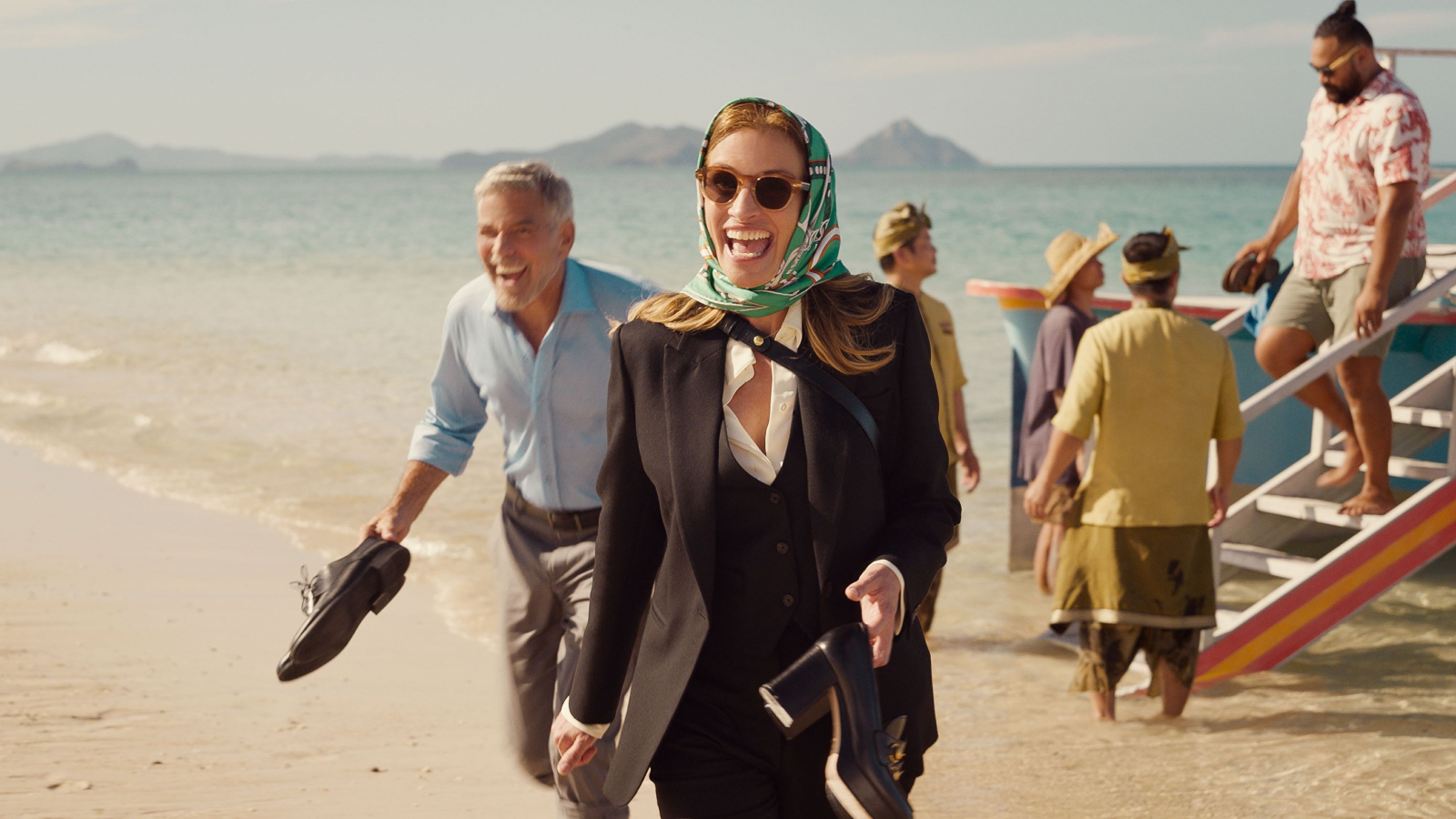 Julia Roberts i George Clooney w romantycznej komedii „Bilet do raju”, radośnie spacerują po plaży.