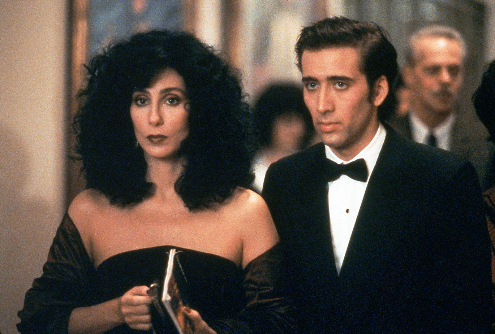 Cher i Nicolas Cage w eleganckich strojach, scena z komedii romantycznej „Wpływ księżyca”.