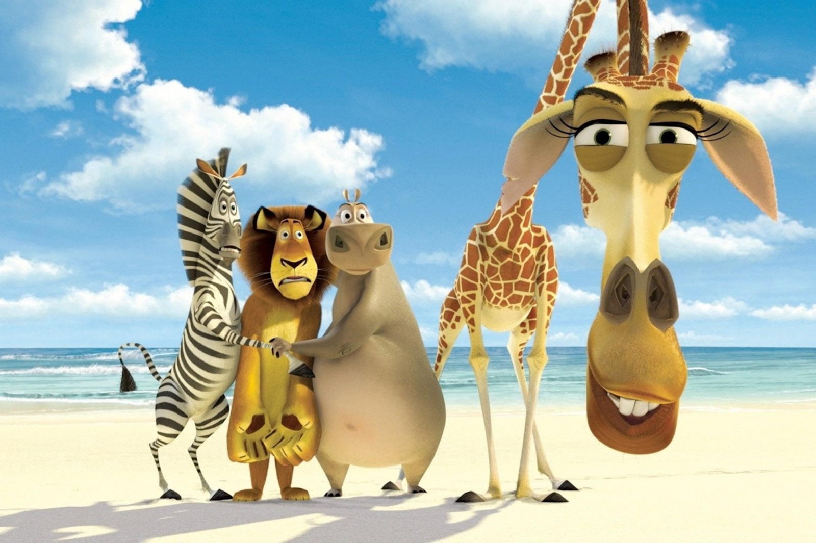 Ekipą zwierząt z filmu „Madagaskar” z 2005 roku na plaży, wśród palm i błękitnego nieba.