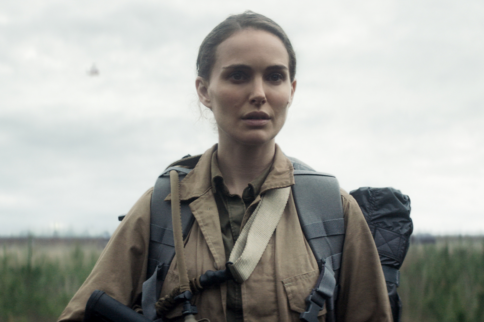 Natalie Portman w filmie Netflix „Anihilacja”, stojąca w lesie z plecakiem i sprzętem do badania.