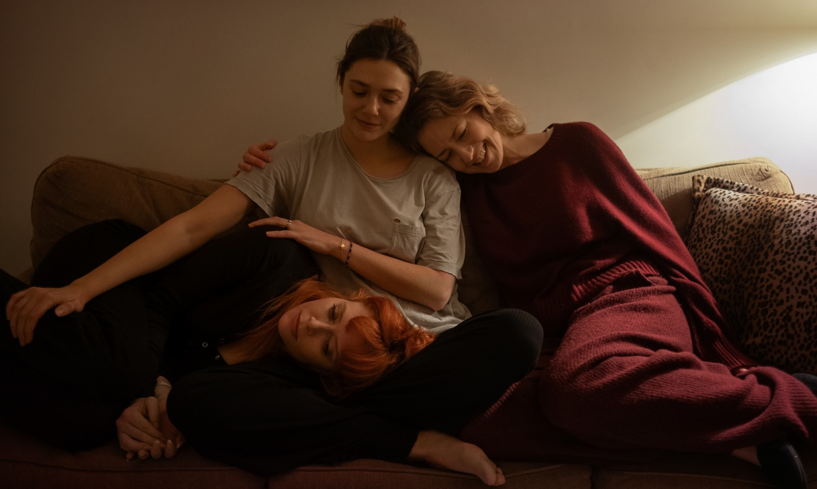 Natasha Lyonne, Elizabeth Olsen i Carrie Coon relaksują się na kanapie w filmie Netflix „Jego trzy córki”.