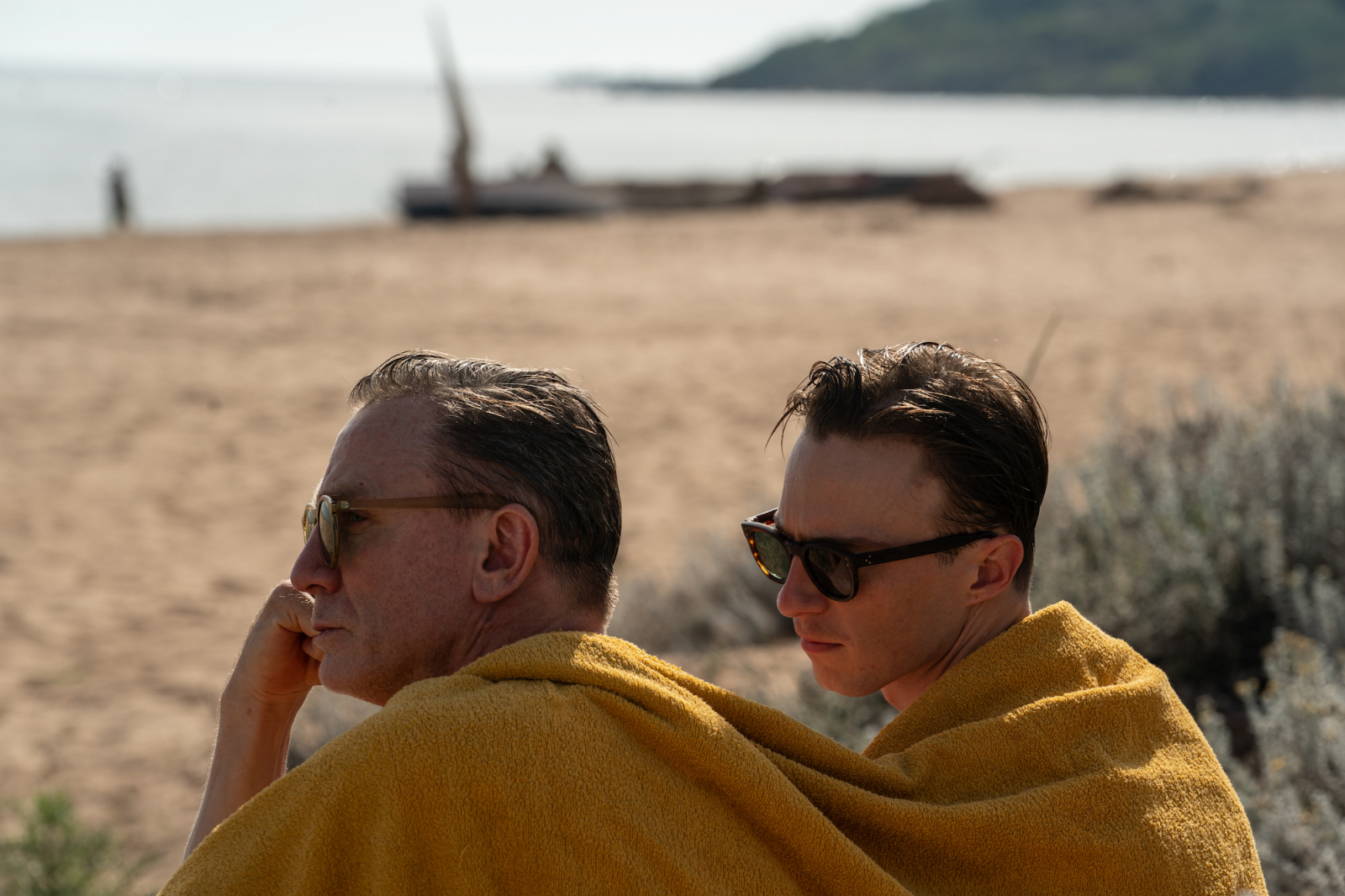 Daniel Craig i Drew Starkey w żółtych ręcznikach na plaży, scena z filmu „Queer”.