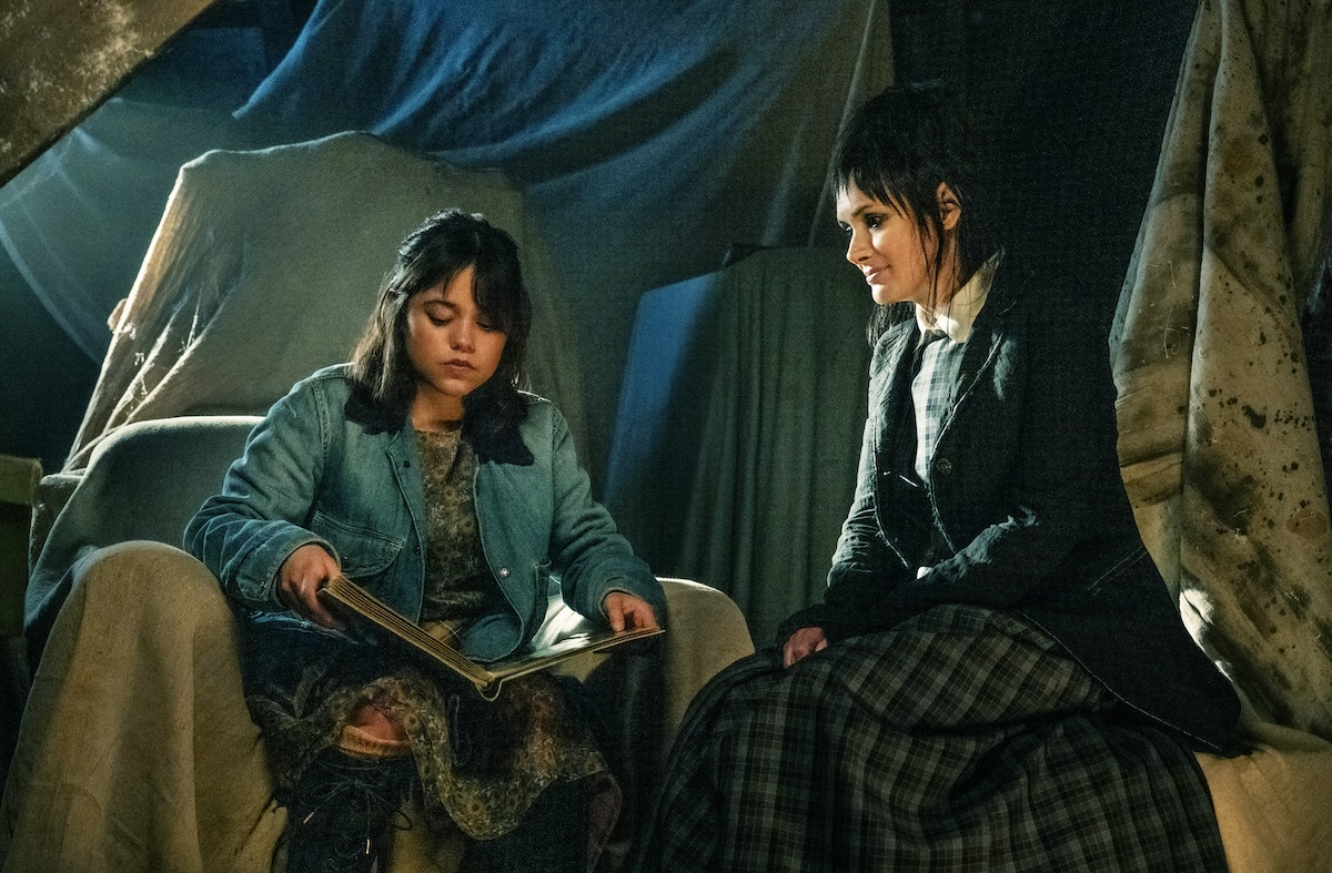 Jenna Ortega i Winona Ryder w filmie &quot;Beetlejuice Beetlejuice&quot;, siedzą razem, jedna czyta książkę.