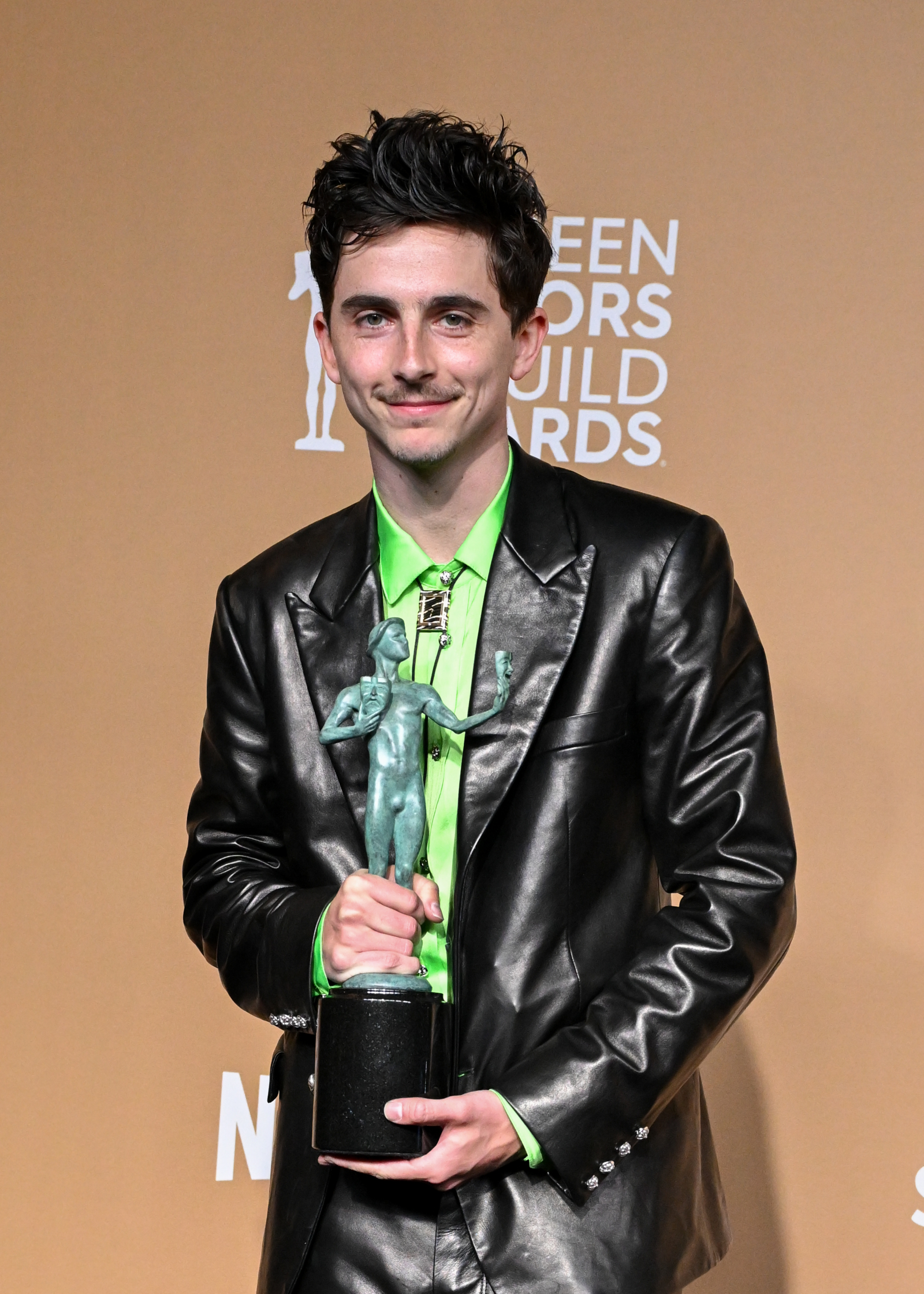 Timothée Chalamet podczas ceremonii wręczenia nagród SAG Awards 2025 trzyma statuetkę.