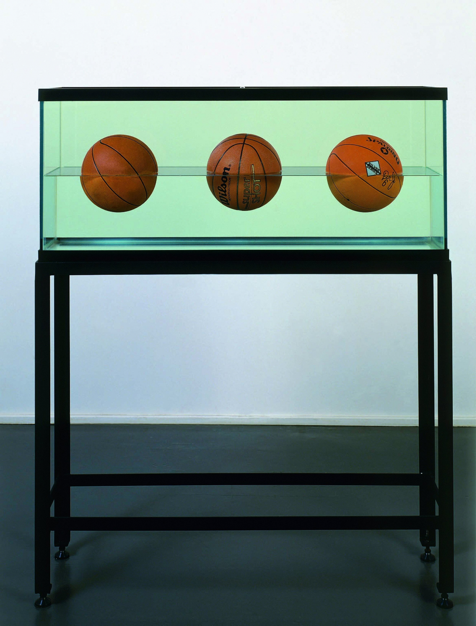 Jeff Koons, Three Ball 50 50 Tank [Wilson Agressor, Wilson Supershot, Dr. J. Silver Series], 1985, trzy piłki koszykowe w przezroczystym zbiorniku.