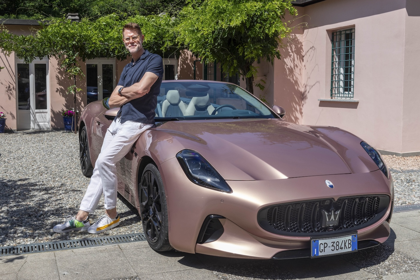 Klaus Busse pozuje obok Maserati GranCabrio Folgore, w słonecznym otoczeniu.