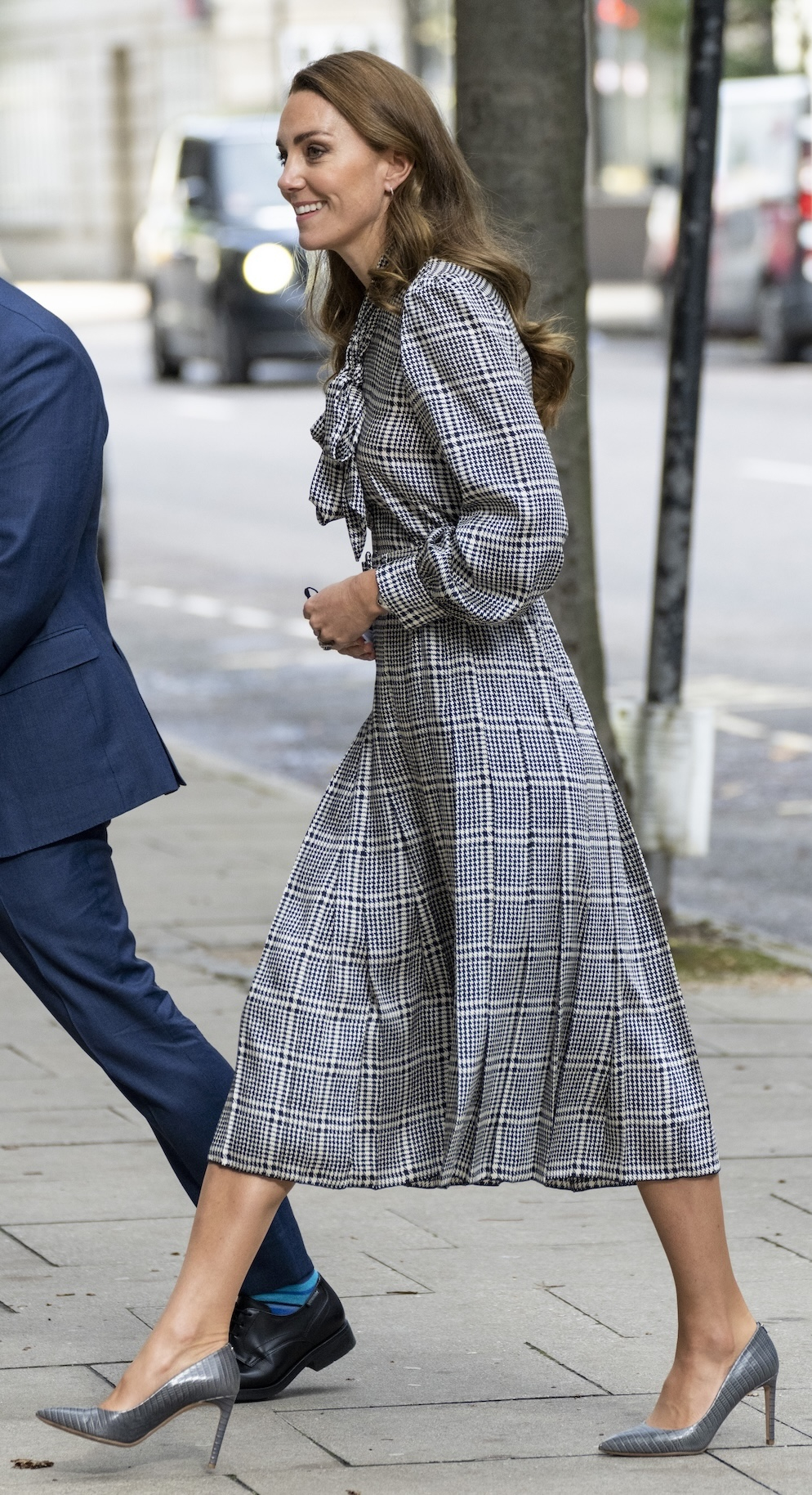 Księżna Kate w sukience wizytowej z Zary i eleganckich szpilkach w stalowym kolorze, uśmiecha się podczas oficjalnej wizyty w Londynie.