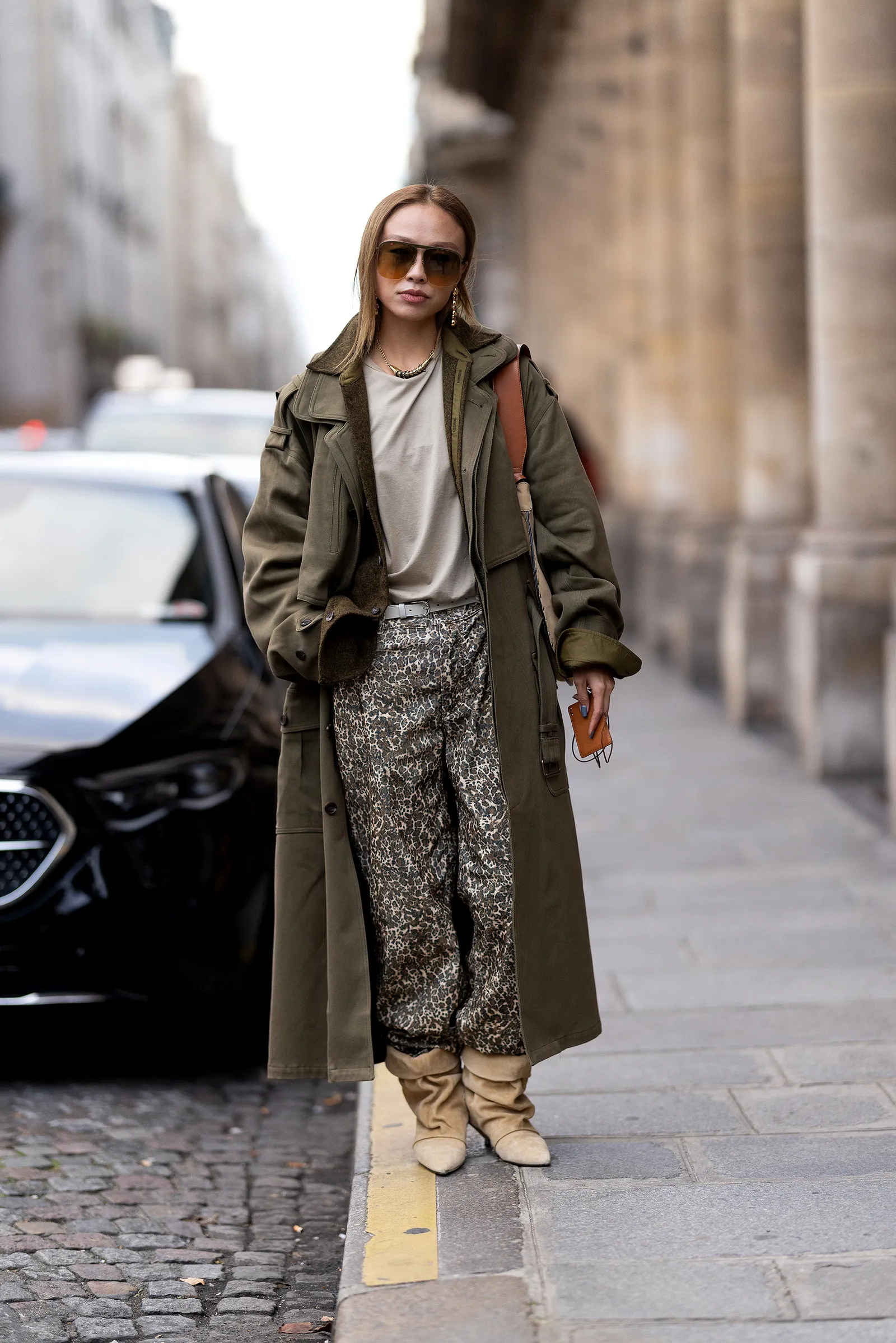 Street style uwielbia zamszowe kozaki z marszczoną, szeroką cholewką jako akcent dodający niezbędnej elegancji spodniom z motywem zwierzęcym (Fot. Valentina Frugiuele / Getty Images)