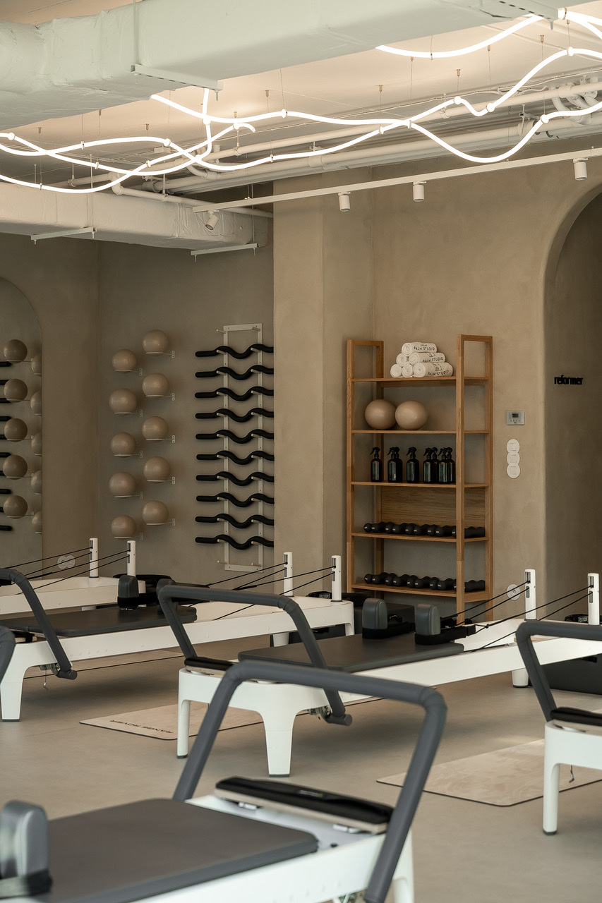 Nowoczesna sala do ćwiczeń w Palm Studio, z reformerami do treningu pilates.